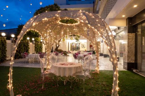 a table and chairs under an arch with lights at Hotel CASA Aishbagh in Lucknow