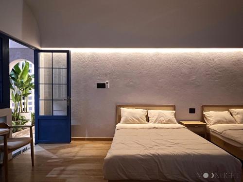 1 dormitorio con 2 camas y puerta azul en MOONLIGHT Homestay & Hotel, en Pleiku