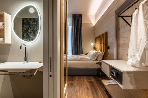 a bathroom with a sink and a bed in a room at Calepina Alpine Suite in Trento