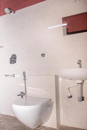 a bathroom with a toilet and a sink at Deepwoods Stay-Kinathukadavu, Coimbatore in Coimbatore