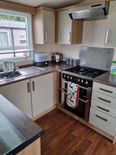 a small kitchen with a stove and a sink at Beautiful 3 bed holiday home in Port Seton