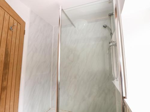 a shower with a glass door in a bathroom at Byre Cottage 1 in Pulborough