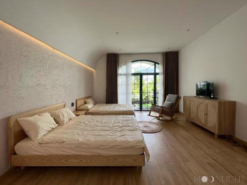 MOONLIGHT Homestay & Hotel في بلاي كو: غرفة نوم بسريرين وتلفزيون فيها