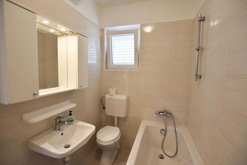 a bathroom with a sink and a toilet and a shower at Apartment Marin in Primošten