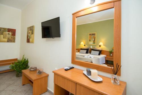 a hotel room with a mirror and a bed at Spira Studios & Apartments in the Heart of Laganas in Laganas