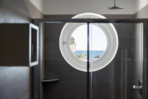 a bathroom with a round window in the shower at Oneweek Gaeta Suites and Apartments in Gaeta