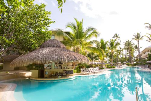a swimming pool at a resort with palm trees at Impressive Premium Punta Cana - All Inclusive in Punta Cana