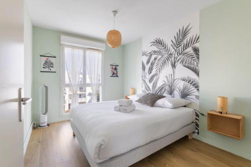 Le Manuka - avec terrasse et parking في نانت: غرفة نوم مع سرير أبيض كبير مع لوحة جدارية نباتية على الحائط