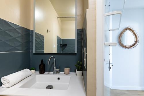 a bathroom with a white sink and a shower at Le Manuka - avec terrasse et parking in Nantes