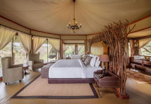 um quarto com uma cama numa tenda em TARANGIRE KURO TREETOP LODGE em Manyara