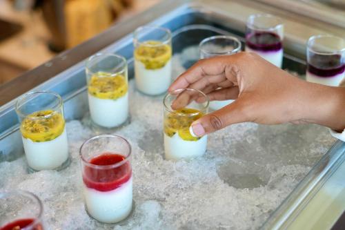 a person holding a drink in a tray with many drinks at Amina Residency in Male City