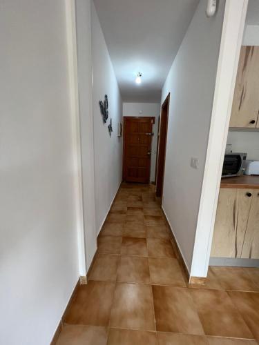 a hallway with white walls and a wooden door at Garajonay in Puerto del Rosario