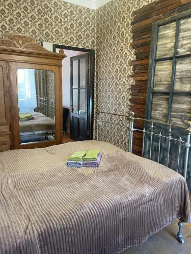 - une chambre avec un lit et un grand miroir dans l'établissement Silve Apartment, à Tbilissi