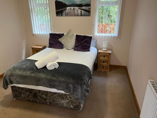 1 dormitorio con 1 cama con 2 toallas en Holly Cabin with Hot Tub en York
