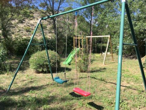 an empty swing set in a yard at La Françonne- Gîte Rouge - Drôme Provençale in Mirabel-aux-Baronnies