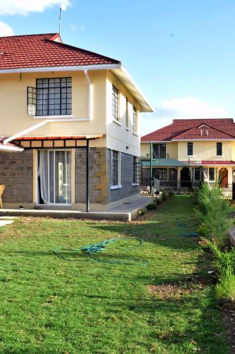 a house with a lawn in front of it at Cheerful 4-bedroom with pool in Athi River