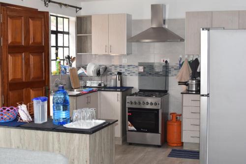 a kitchen with a refrigerator and a stove top oven at Cheerful 4-bedroom with pool in Athi River