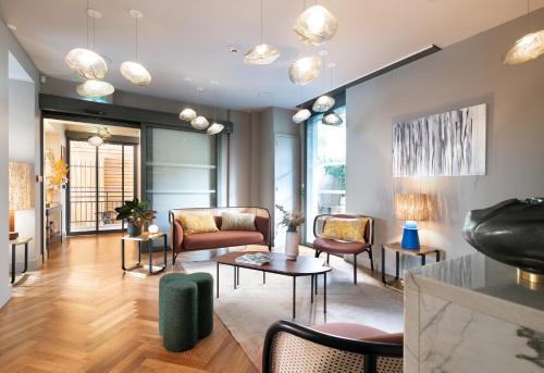 - un salon avec des chaises, un canapé et des tables dans l'établissement Hébé Hotel, à Annecy