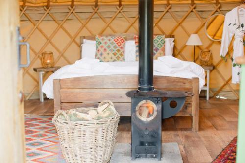 een houtkachel in een kamer met een bed bij Yurtshire Fountains - Wensley Yurt in Ripon