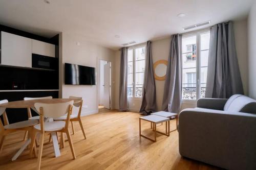 un salon avec un canapé et une table dans l'établissement Welcoming 1 Bedroom Apartment in Paris, à Paris