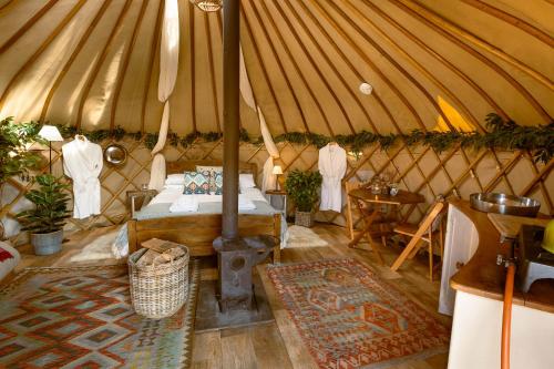 a yurt with a bed and a stove in it at Yurtshire Fountains - Wensley Yurt in Ripon