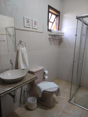 e bagno con servizi igienici, lavandino e doccia. di Pousada Caminho da Serra a São Roque de Minas