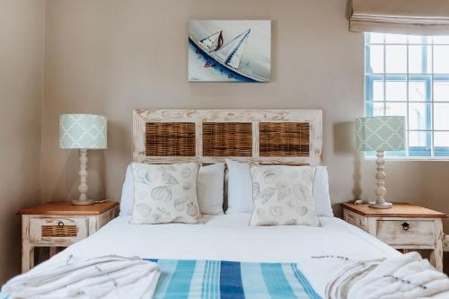 a bedroom with a white bed with two lamps at Duifie in Paternoster
