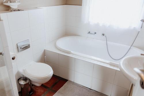 a bathroom with a toilet and a tub and a sink at Duifie in Paternoster