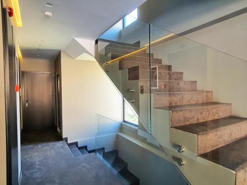 a staircase in a house with a glass wall at Meraviglia Boutique Hotel in Sarandë