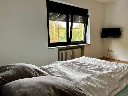 ein unverbautes Bett in einem Schlafzimmer mit einem Fenster in der Unterkunft Monteurwohnung Mönchengladbach Geroweiher in Mönchengladbach