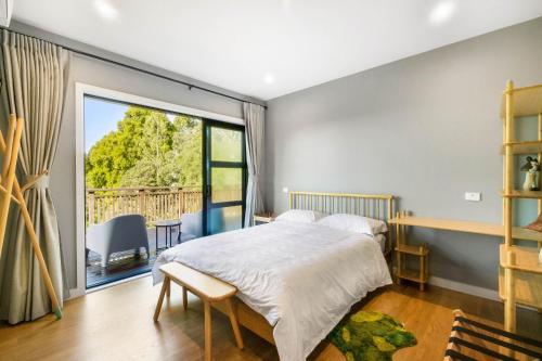 a bedroom with a bed and a large window at Echo Lodge in Auckland