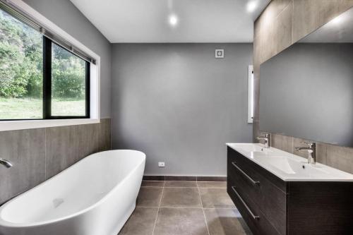 a bathroom with a tub and a sink at Echo Lodge in Auckland