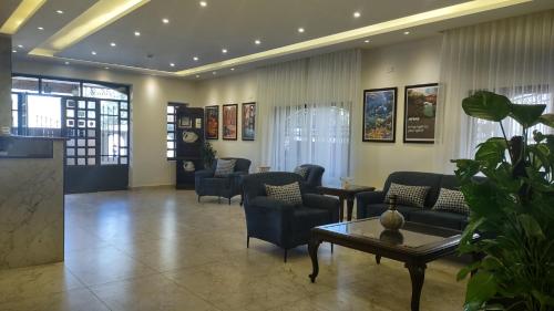 a lobby with couches and chairs and a table at Black Iris Hotel in Madaba