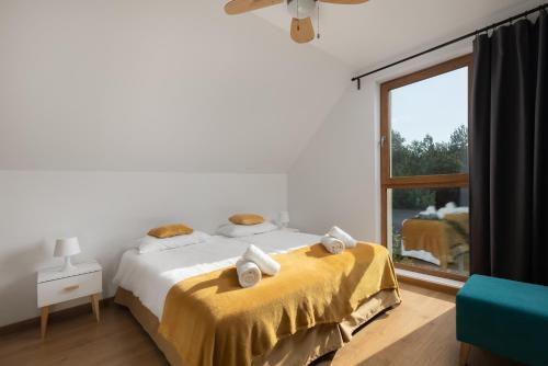 ein Schlafzimmer mit einem Bett mit gelber Bettwäsche und einem Fenster in der Unterkunft Moje Miejsce Jura in Lgota Murowana