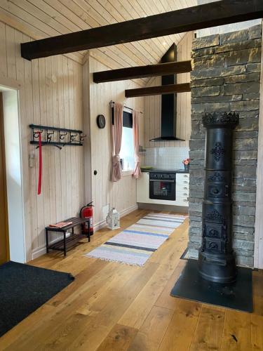 a living room with a stone fireplace and a stove at Bo i egen stuga på härlig ölandsgård in Köpingsvik