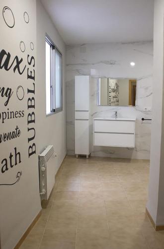 a white bathroom with a sink and a mirror at El Recreo, private Pool & Bbq in Godelleta