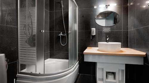 y baño con ducha, lavabo y espejo. en HERMITAGE by Elenis, en Sfântu-Gheorghe