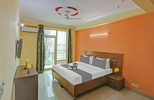 een slaapkamer met een groot bed met een oranje muur bij Hotel Ashvins Palace in Gurgaon