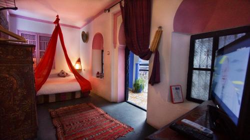 a bedroom with a bed and a tv in a room at Hotel Casa Miguel in Chefchaouene