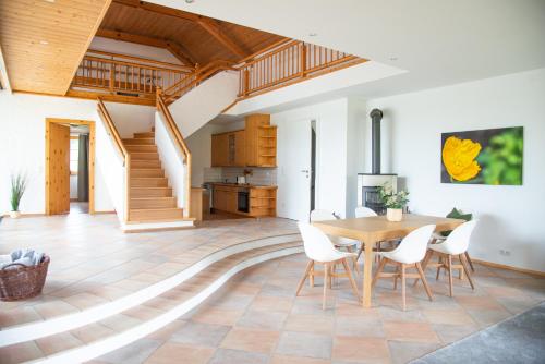 a kitchen and dining room with a wooden table and chairs at Seehof direkt am See in Seeleiten