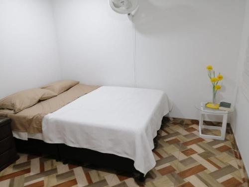 - une chambre avec un lit blanc et une table dans l'établissement Apartamento en conjunto hacienda Peñaliza Limonar, à Ricaurte