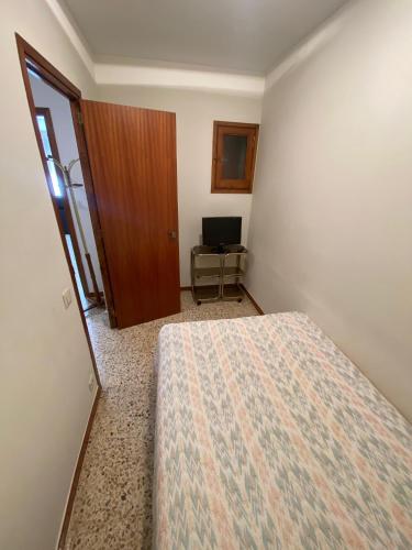 a bedroom with a bed and a door and a desk at Apartaments Sant Antoni in Ribes de Freser