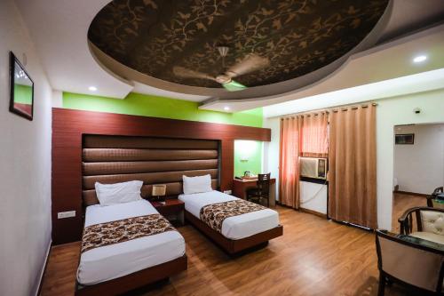 a hotel room with two beds and a large ceiling at HOMANSH GALAXY HOTEL in Kānpur