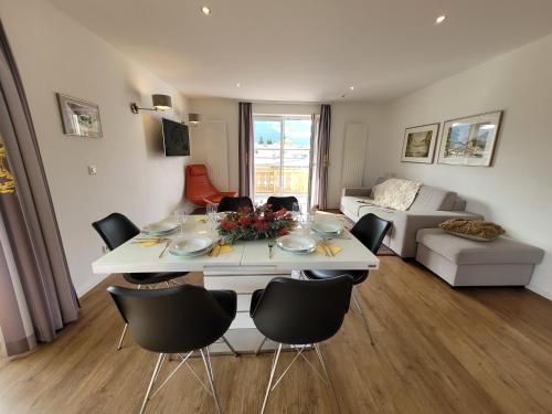 een woonkamer met een witte tafel en stoelen bij Panorama Apartments - Steinbock Lodges in Zell am See