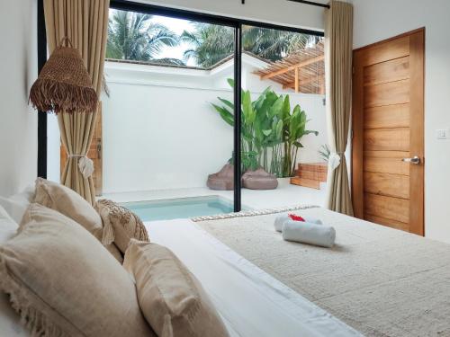 エルニドにあるBahala Na Villasのベッドルーム1室(ベッド1台付)、スイミングプールが備わります。