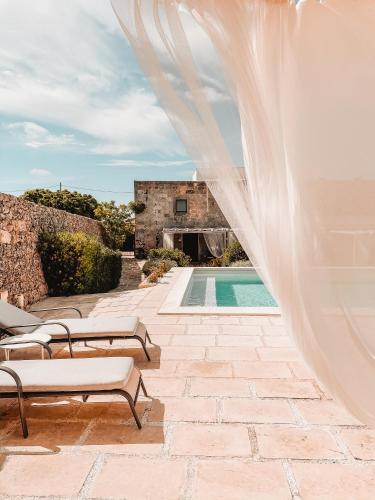 un velo nuziale sopra un patio con piscina di Masseria Palane a Patù