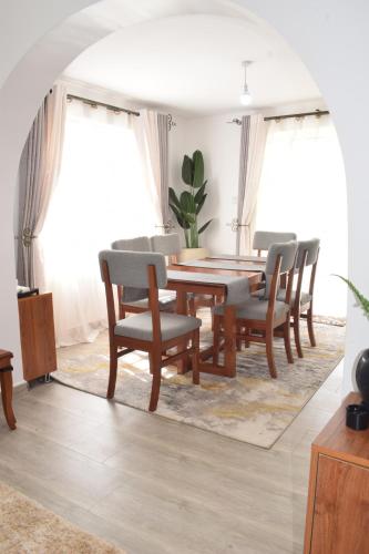 a dining room with a wooden table and chairs at Cheerful 4-bedroom with pool in Athi River