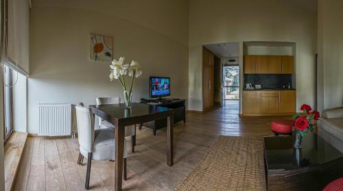 a living room with a dining room table and a kitchen at Euphoria Club Hotel in Borovets