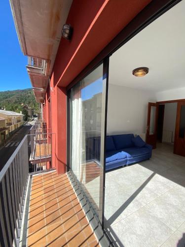 a balcony with a blue couch on the side of a building at Apartaments Sant Antoni in Ribes de Freser