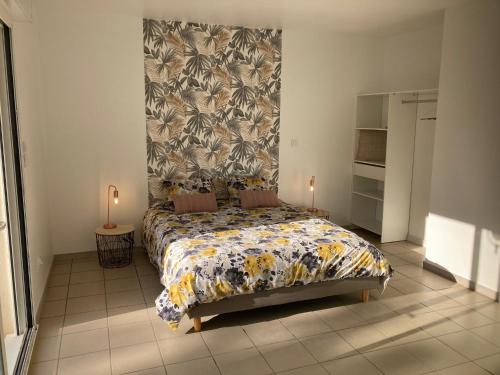 ein Schlafzimmer mit einem großen Bett mit einer Blumenbettdecke in der Unterkunft Villa avec son spa privatif proche de Rocamadour in Gramat
